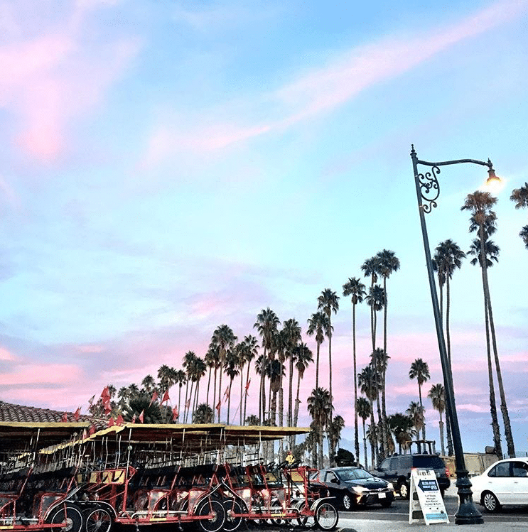 Surrey bikes parked along East Cabrillo Blvd at sunset in Santa Barbara