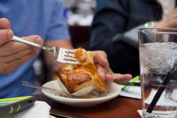 a person sitting at a table with a plate of food