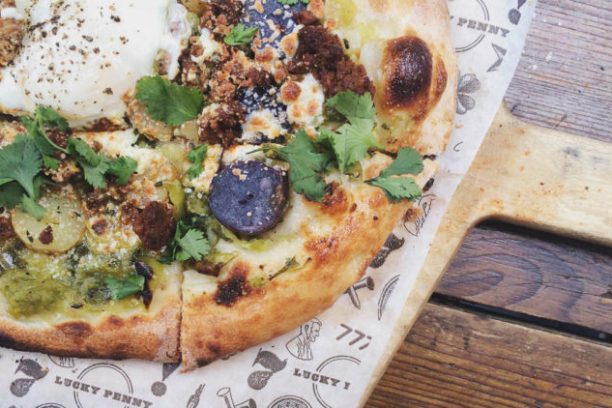 a pizza sitting on top of a wooden cutting board