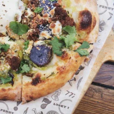 a pizza sitting on top of a wooden cutting board