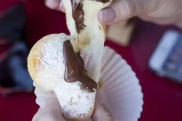 a hand holding a donut