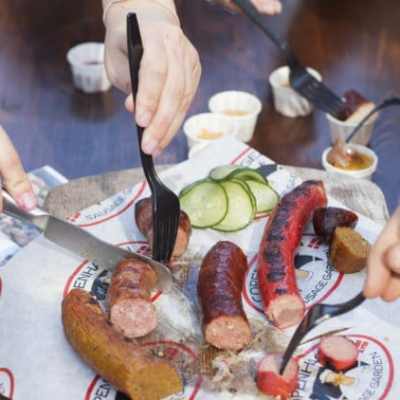 a person holding a plate of food on a table