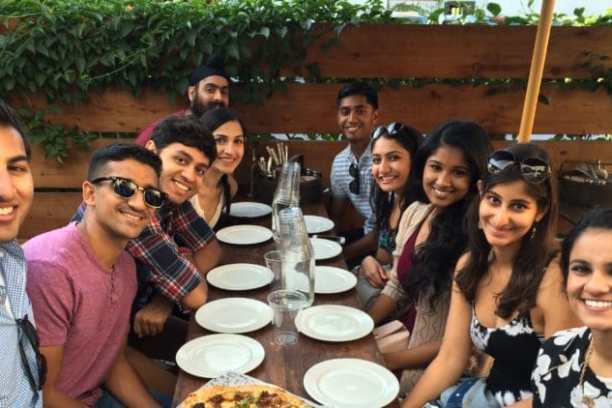 a group of people sitting at a table posing for the camera