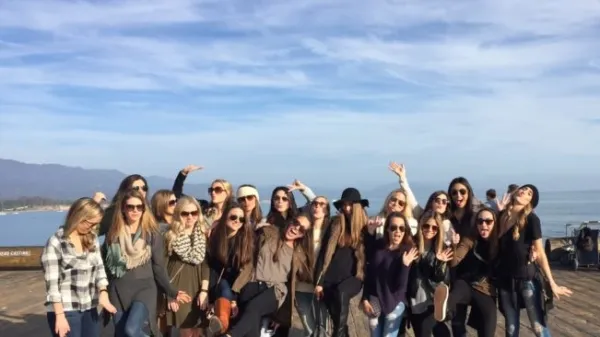 a group of people posing in front of a body of water