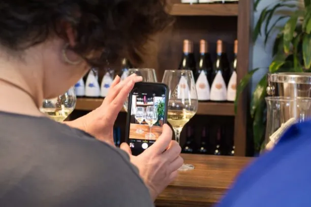 a person sitting at a table with wine glasses